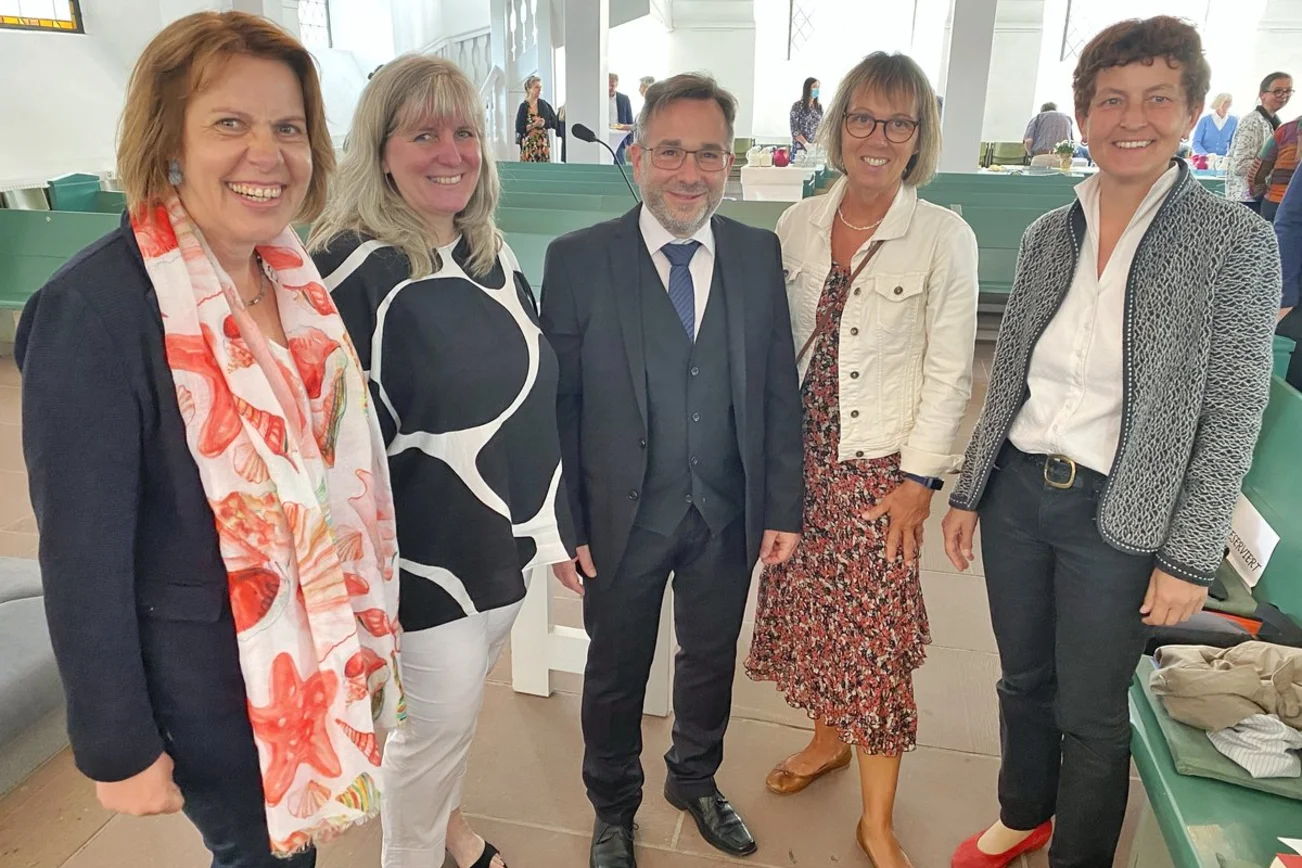 Eine Gruppe von Menschen lächelt in die Kamera. 