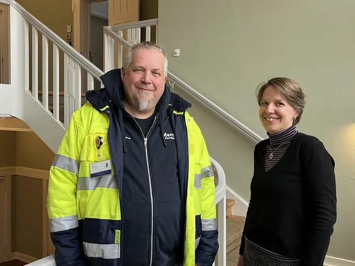 Ein Mann und eine Frau stehen vor einem Treppengeländer.