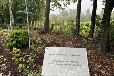 Ein Schild vor einer Grabanlage mit der Aufschrift Mensch-Haustier-Grabanlage