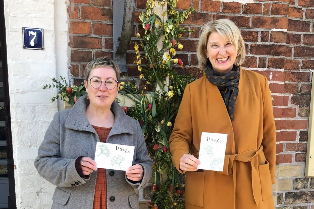 Zwei Personen stehe mit einer Karte vor einem Gebäude