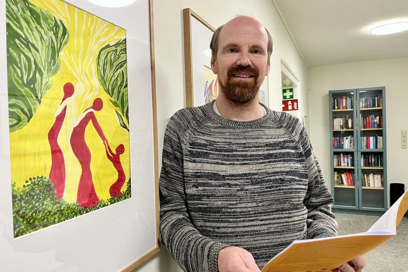 Ein Mann mit Bart lächelt den Betrachter an.