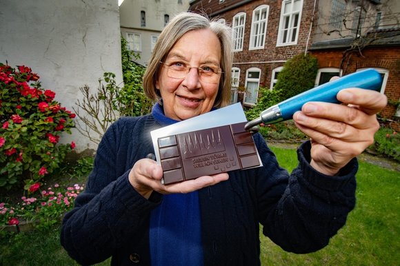 Eine Frau zeigt eine Tafel Schokolade