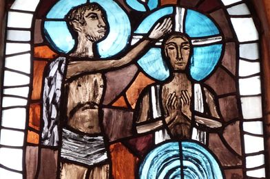 Johannes der Täufer tauft Jesus im Jordan - als buntes Rundbogenfenster im Sterleyer Altarraum vom Künstler Claus Wallner in den Farben Weiß, Grau, Braun und Blau. - Copyright: Andreas Wegenhorst