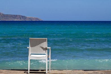 Weißer Stuhl am Strand mit Blick auf das blaue Meer - Copyright: Foto:Lotz - Gemeindebrief.de