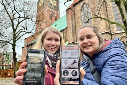 Zwei Frauen stehen vor einer Kirche und halten Smartphones in die Kamera.  - Copyright: Bastian Modrow