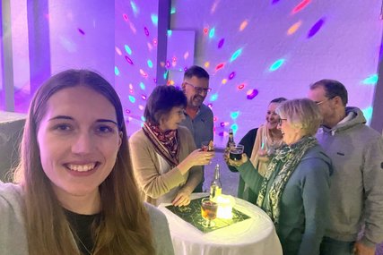 Eine junge Frau im Vordergrund mit mehreren Menschen in einem Partyraum. - Copyright: Marie Schumann