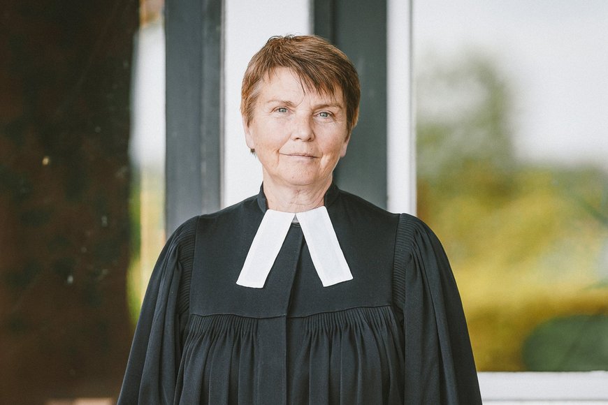 Frau im Talar schaut zuversichtlich in die Kamera - Copyright: Guido Kollmeier