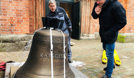 Prüfender Blick: Christian Rosehr, Vorsitzender des Kirchengemeinderates, begutachtet die Glocke, die Monteur Jürgen Schwarck aus dem LKW bugsiert.