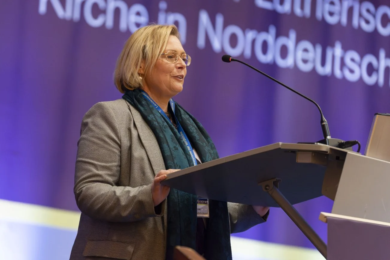 Eine Frau steht an einem Rednerpult.