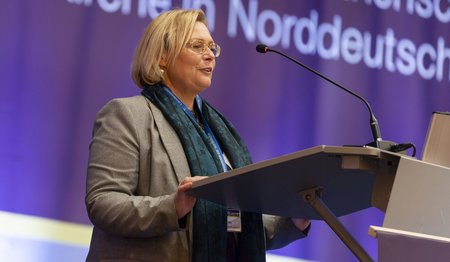 Eine Frau steht an einem Rednerpult.