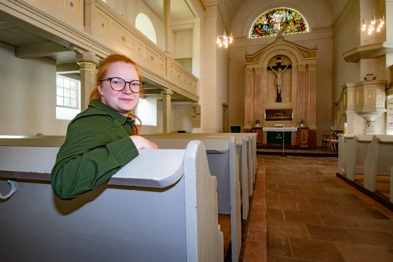 Eine Frau sitzt in einer Kirche.