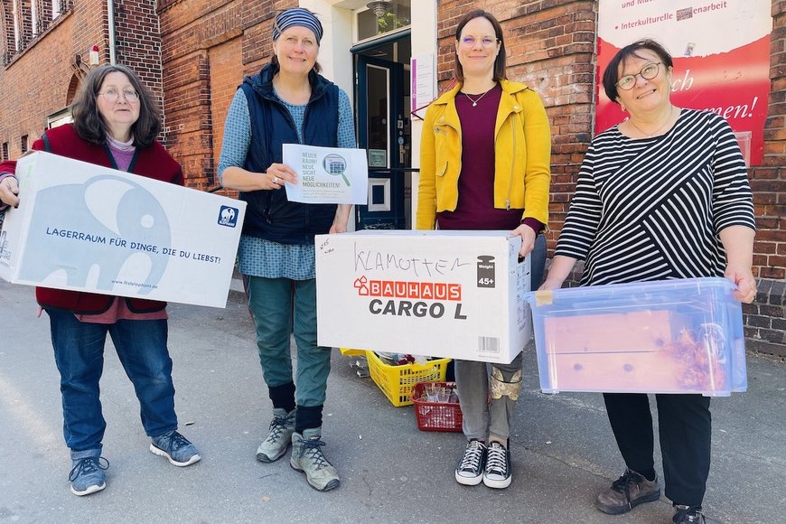 Assistentin Annette Brodderek, Leiterin Silke Meyer, Kurberaterin Saskia Lohff und Yasemin Düzen von der Interkulturellen Begegnungsstätte stehen vor dem ehemaligen Standort des Frauenwerkes mit Umzugskisten in den Händen.  - Copyright: Steffi Niemann