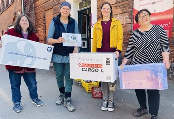 Assistentin Annette Brodderek, Leiterin Silke Meyer, Kurberaterin Saskia Lohff und Yasemin Düzen von der Interkulturellen Begegnungsstätte stehen vor dem ehemaligen Standort des Frauenwerkes mit Umzugskisten in den Händen.  - Copyright: Steffi Niemann