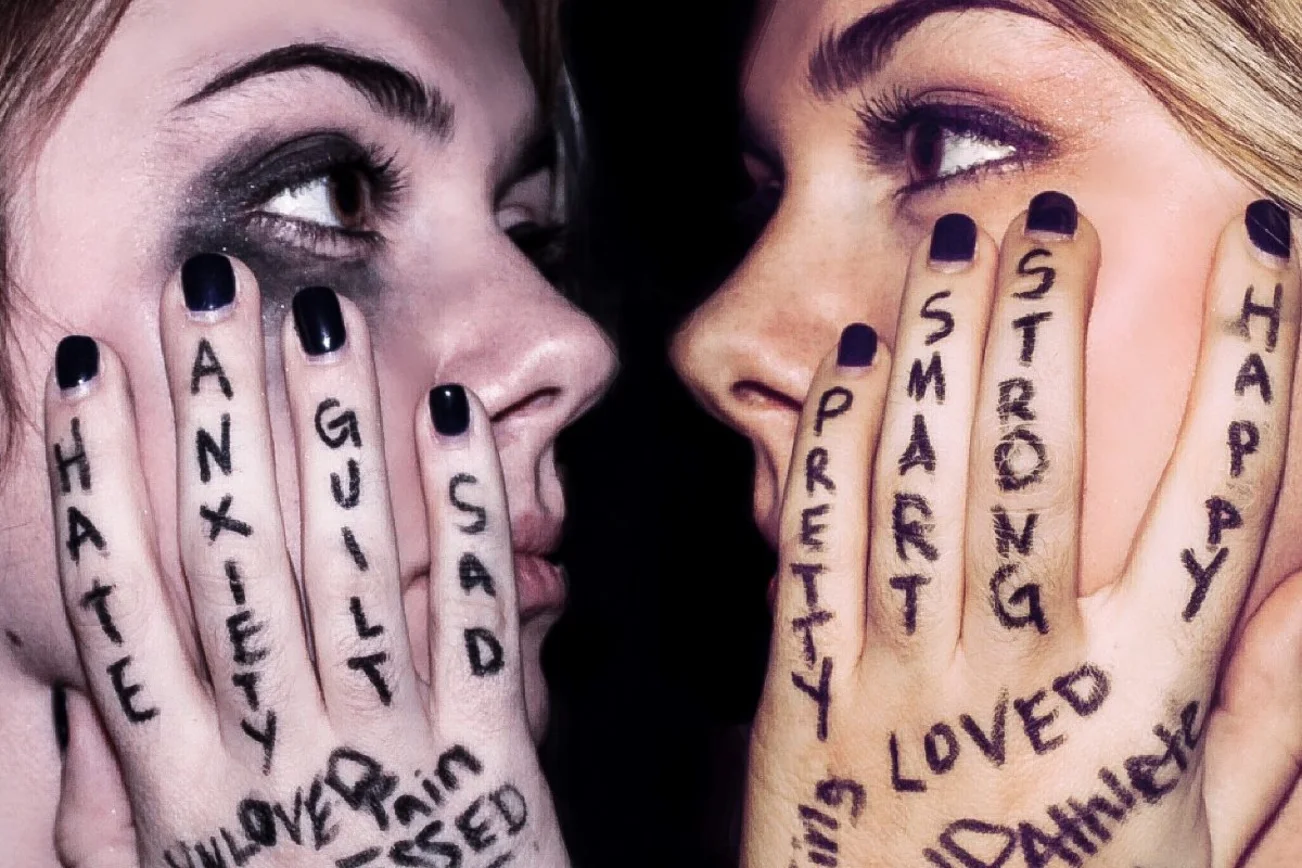 Zwei sich anschauende Gesichter, davor je eine Hand an der Wange. Darauf stehen Wörter wie Hate, Strong usw