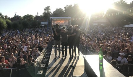 Eine Gruppe vor feiernden Fans im Gegenlicht fotografiert.