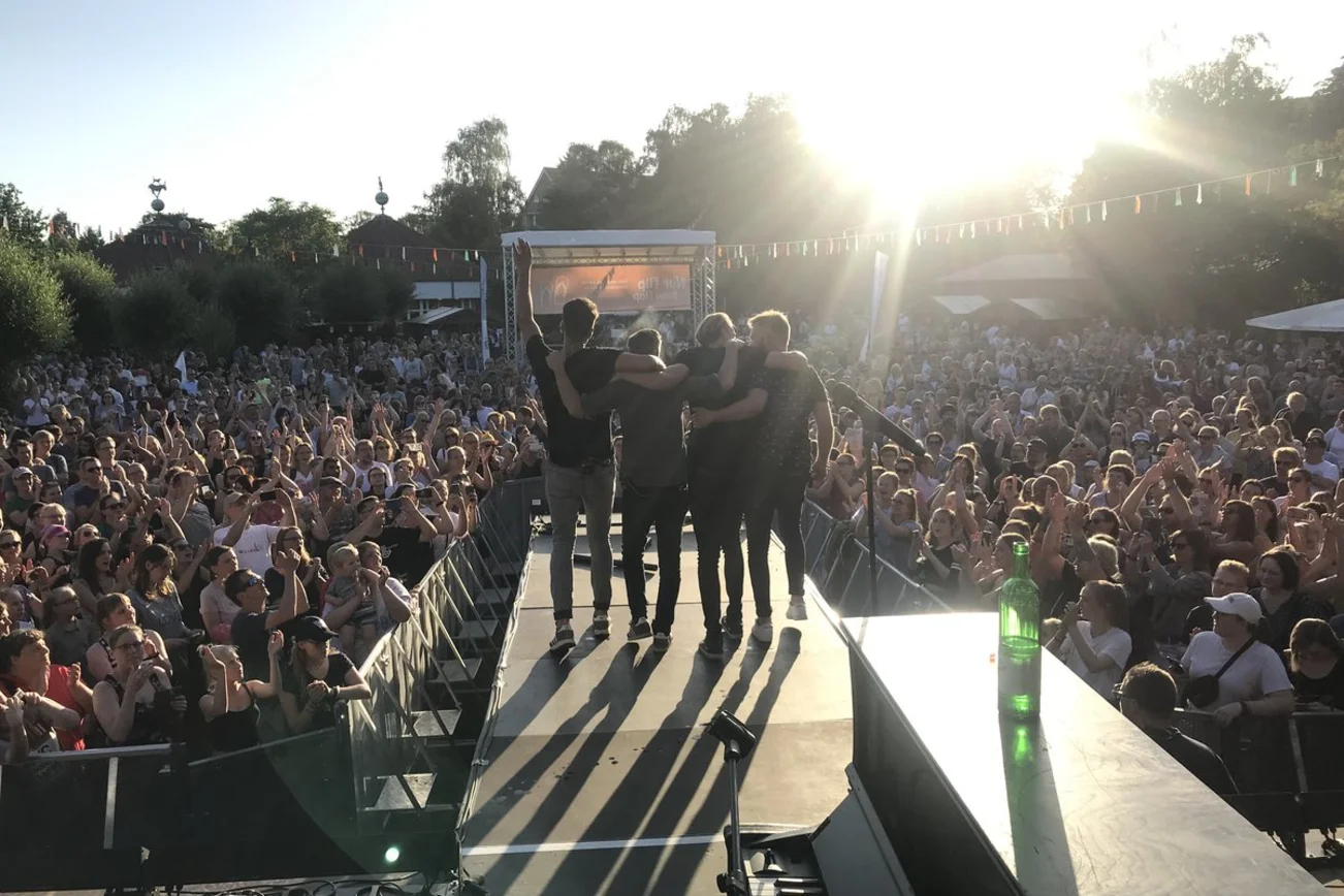 Eine Gruppe vor feiernden Fans im Gegenlicht fotografiert.