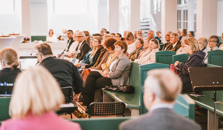 Menschen sitzen in einer Kirche.