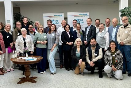 Menschen stehen für ein Foto zusammen - Copyright: Diakonisches Werk RZ