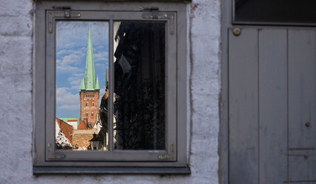 Durch ein Fenster sieht man den St.-Petri-Turm