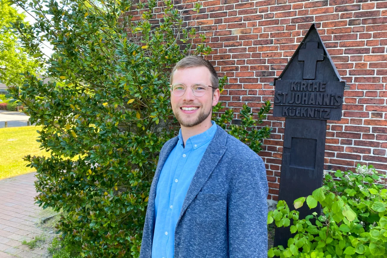 Ein Mann steht vor einer Kirche