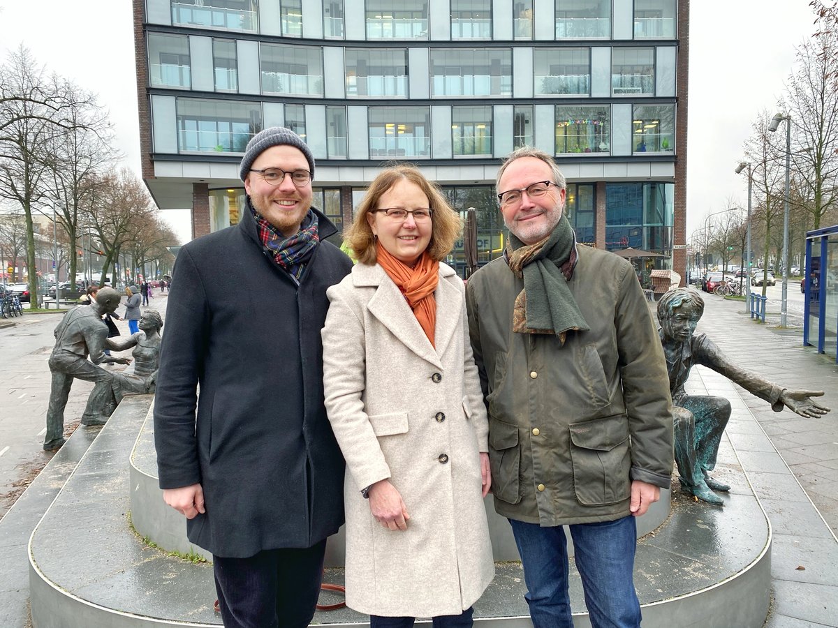 Drei Personen stehen lächelnd auf einem Platz im Lübecker Stadtteil Marli.