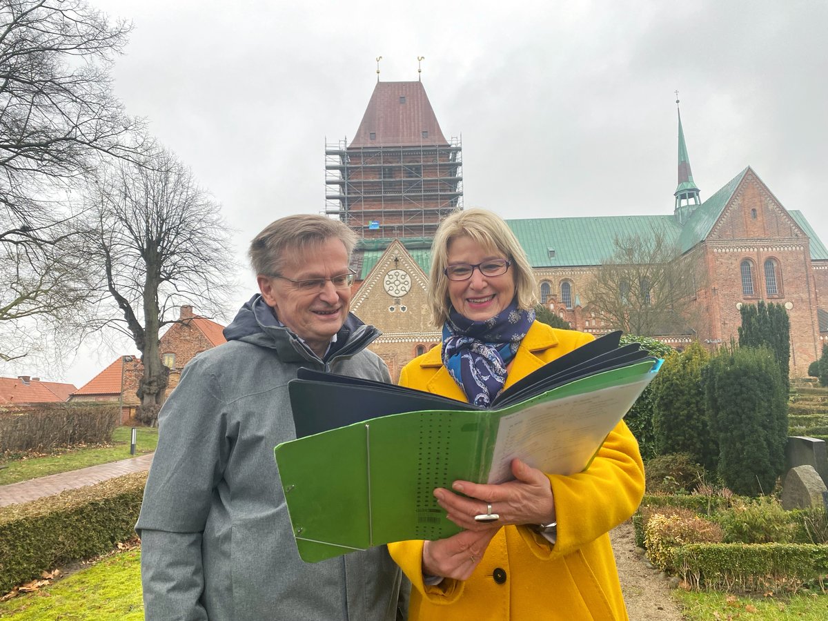 Zwei Personen stehen mit einer Planungsmappe vor dem Ratzeburger Dom.