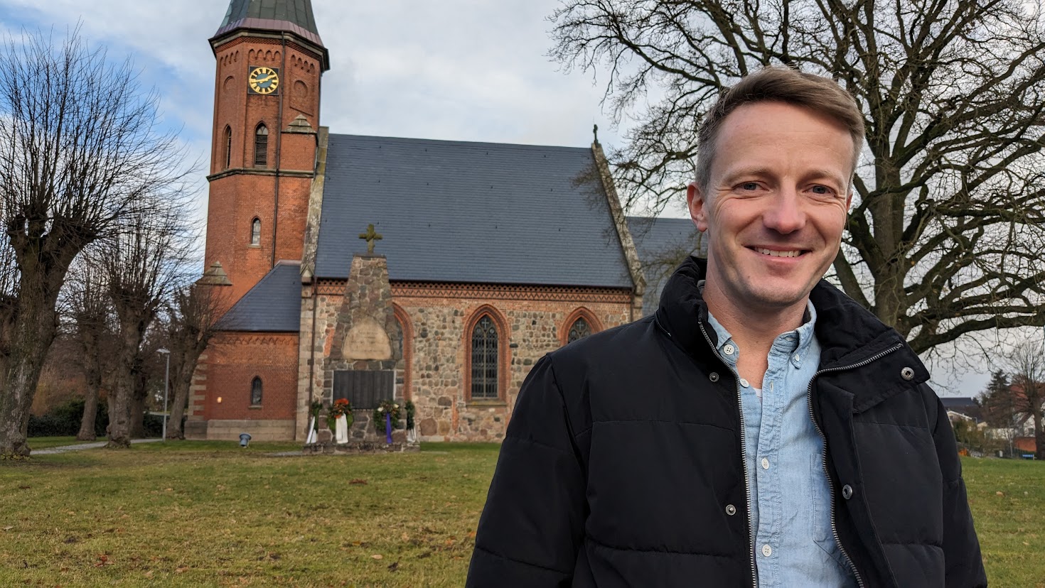 Ein Mann steht vor einer Kirche