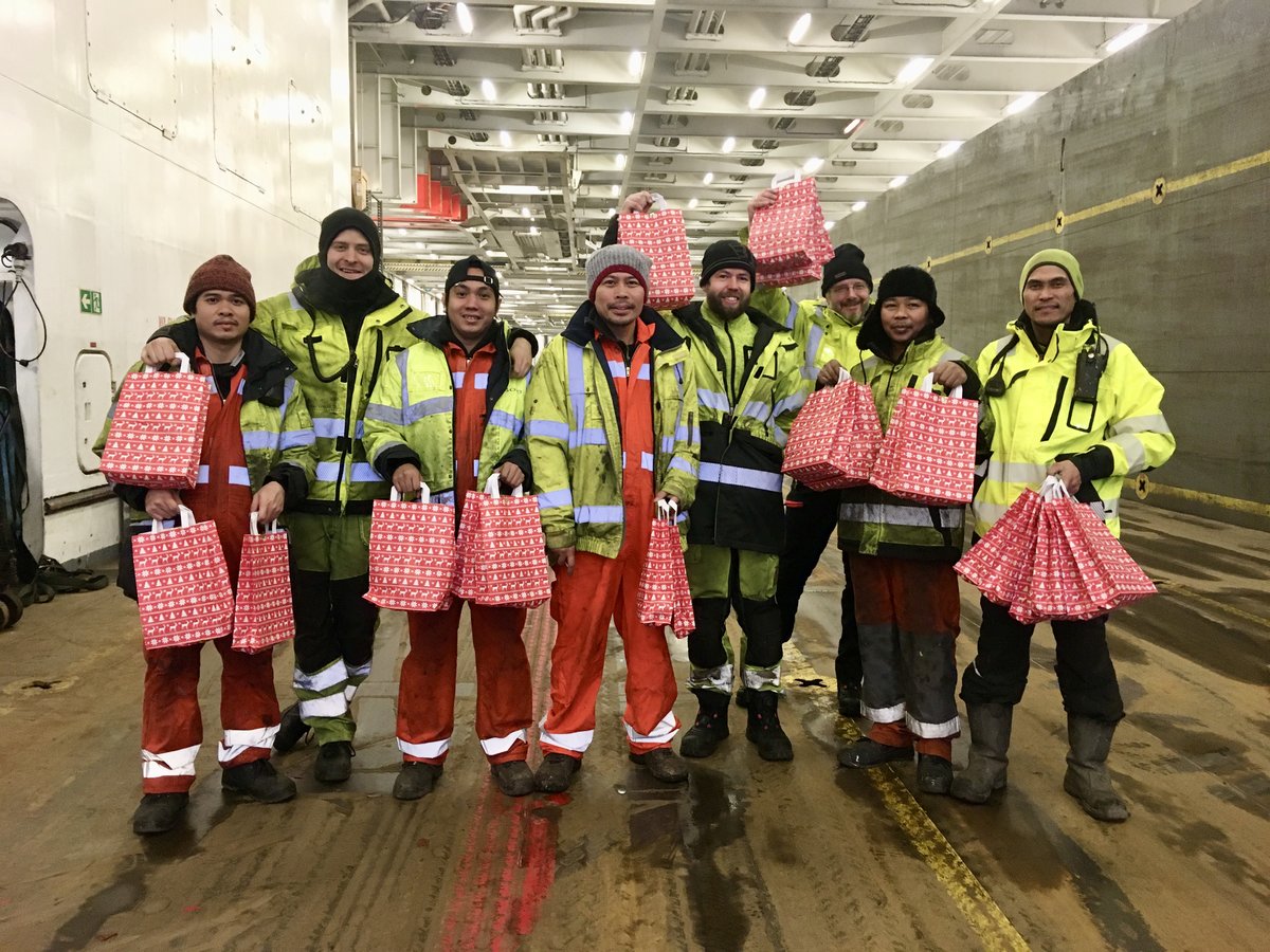 Menschen mit Weihnachtstüten auf einem Schiff