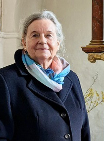 Copyright: Oliver Pries Eine Dame mit grauen Haaren trägt einen dunkelblauen Mantel und ein pastellfarbenes Tuch um den Hals
