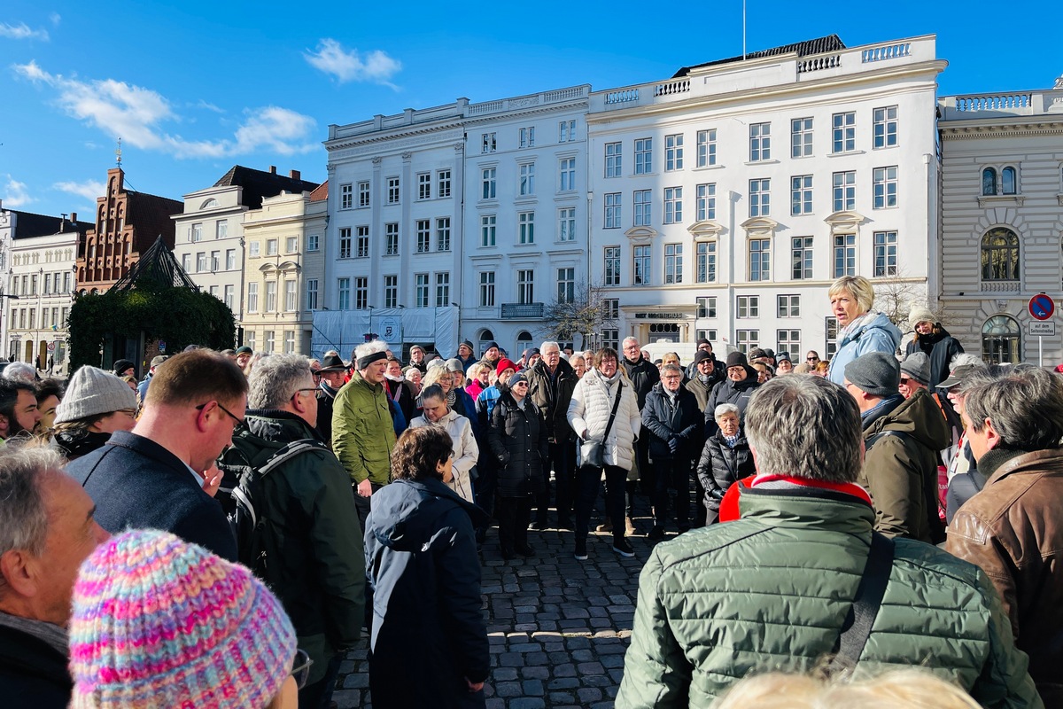 Viele Menschen versammelt um eine Stadtführerin