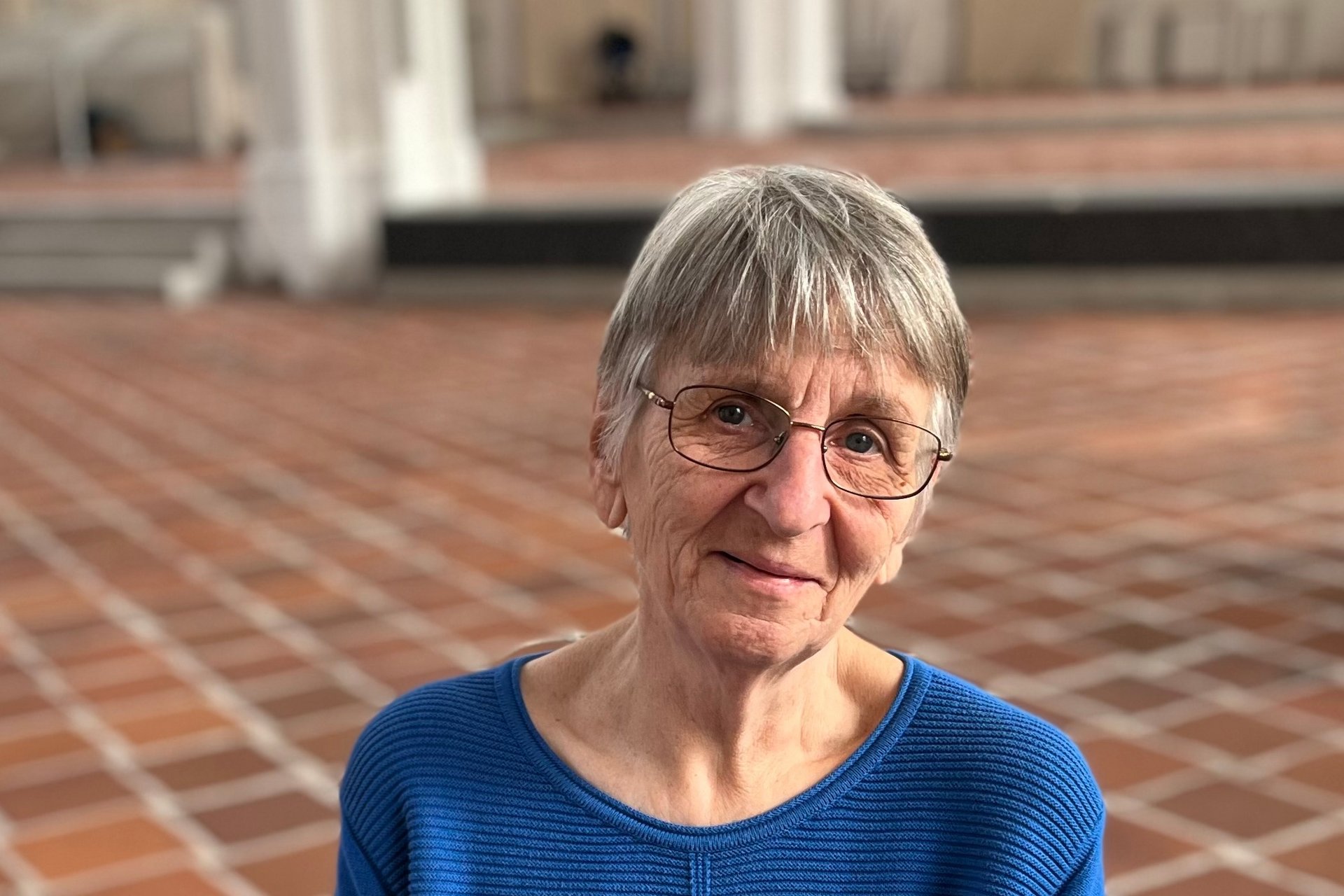 Frau schaut lächelnd in die Kamera.