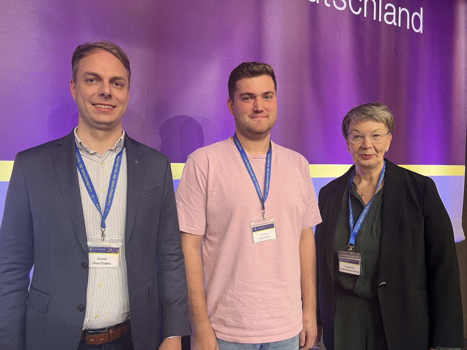 Drei Personen schauen in die Kamera