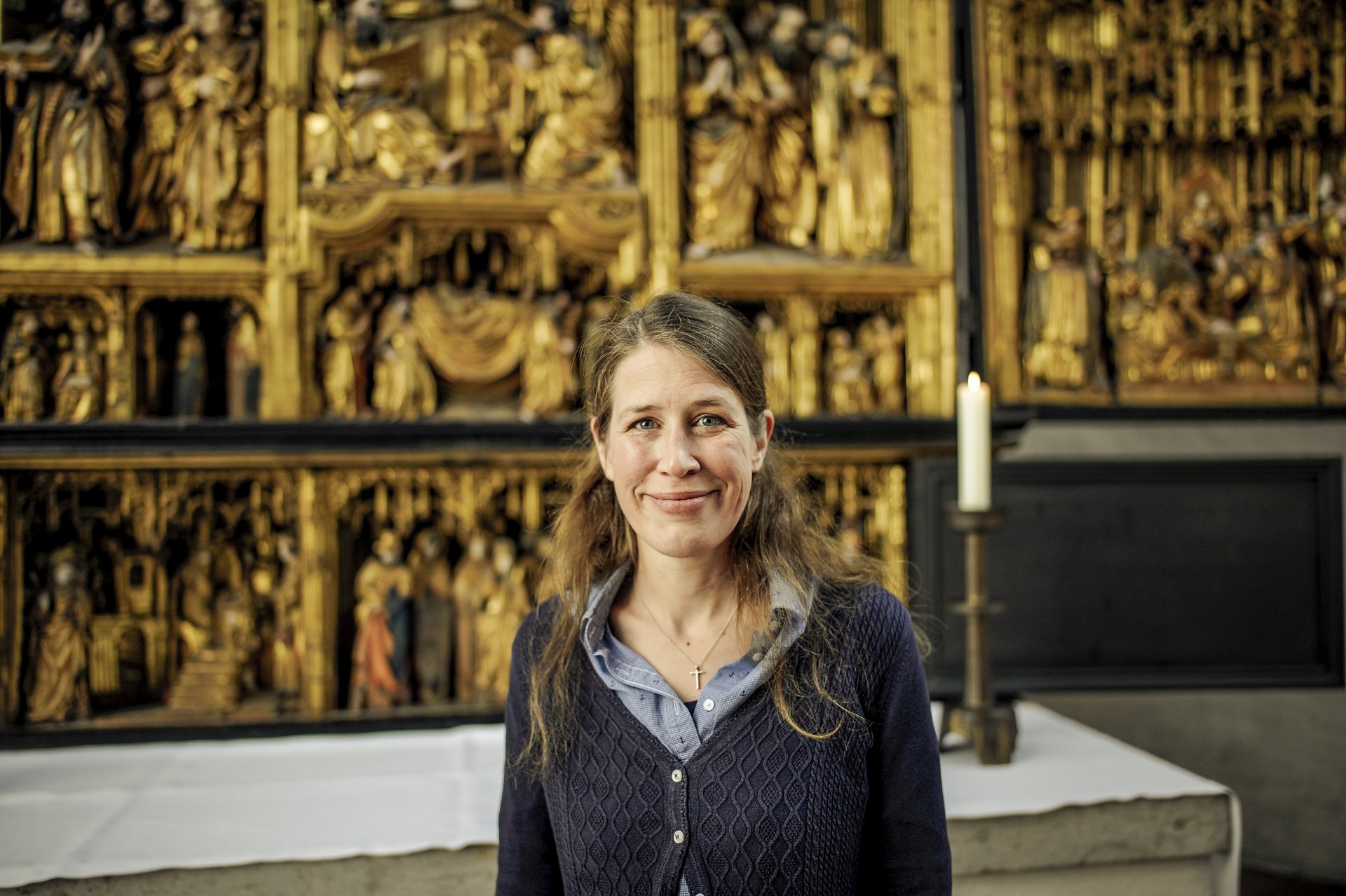 Eine Frau steht lächelnd in einer Kirche