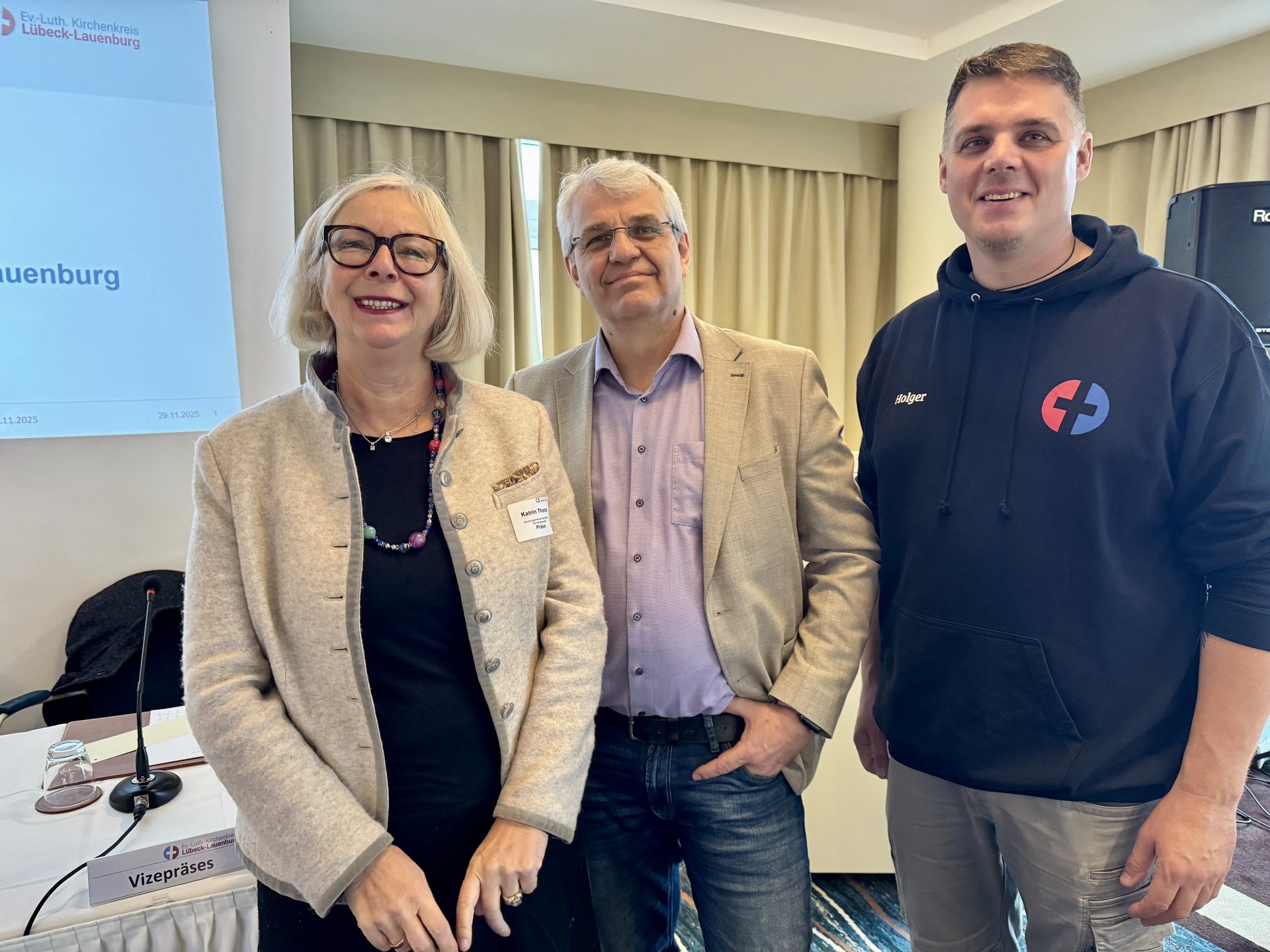 Drei Personen schauen in die Kamera