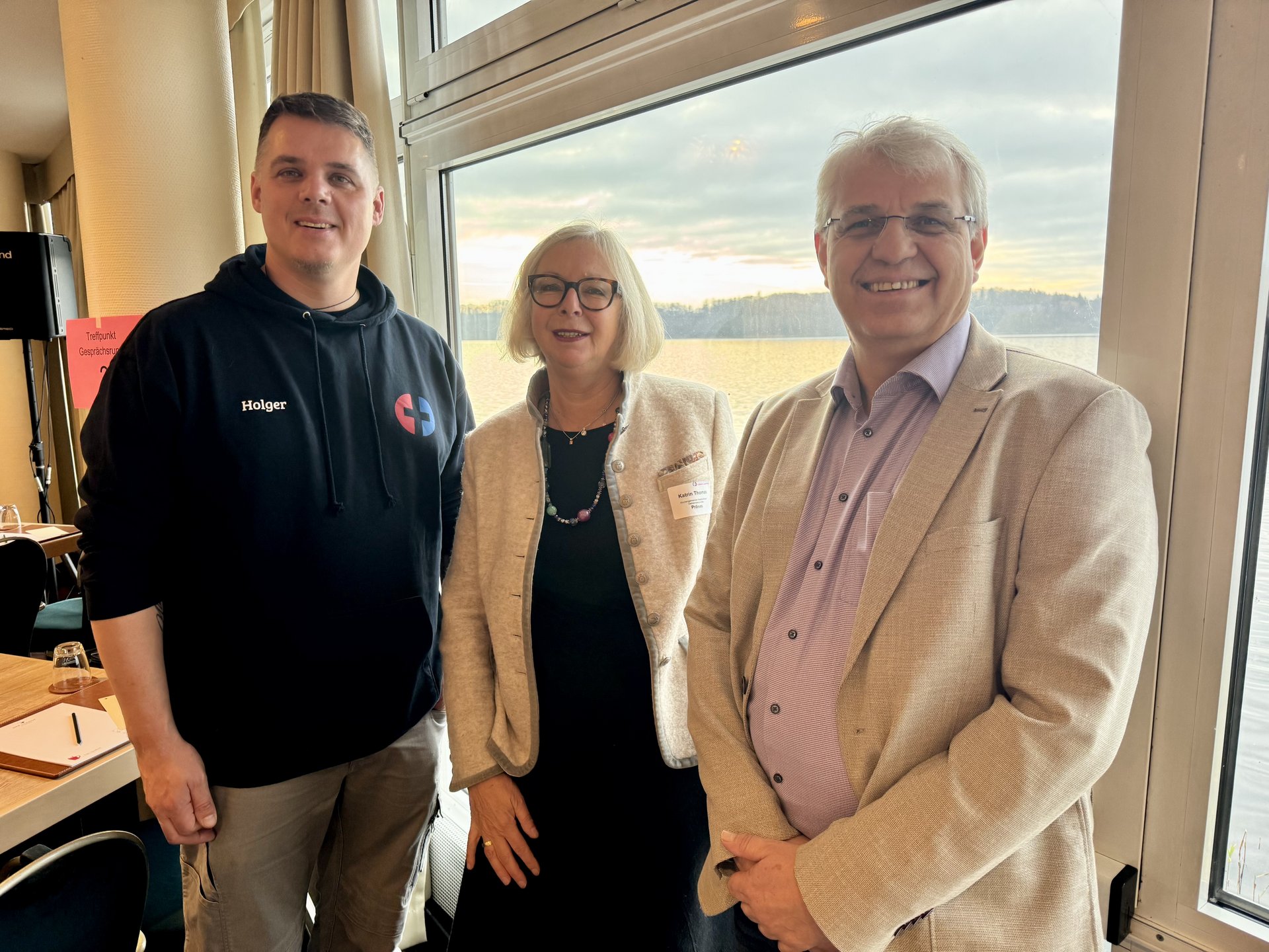 Drei Personen schauen in die Kamera