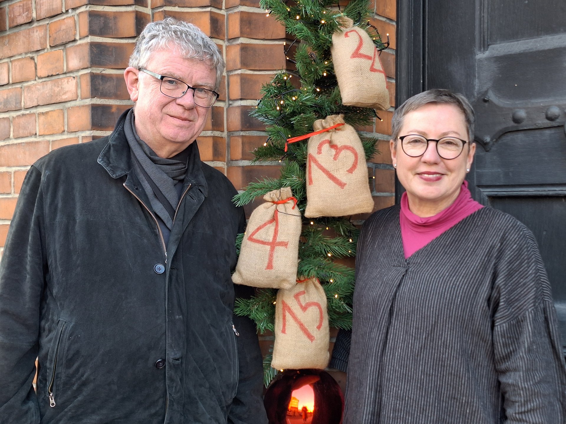 Zwei Menschen vor einer Kirche im Advent