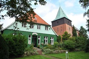 Fasade vom Pastorat in Krummesse mit dem Kirchturm im Hintergrund