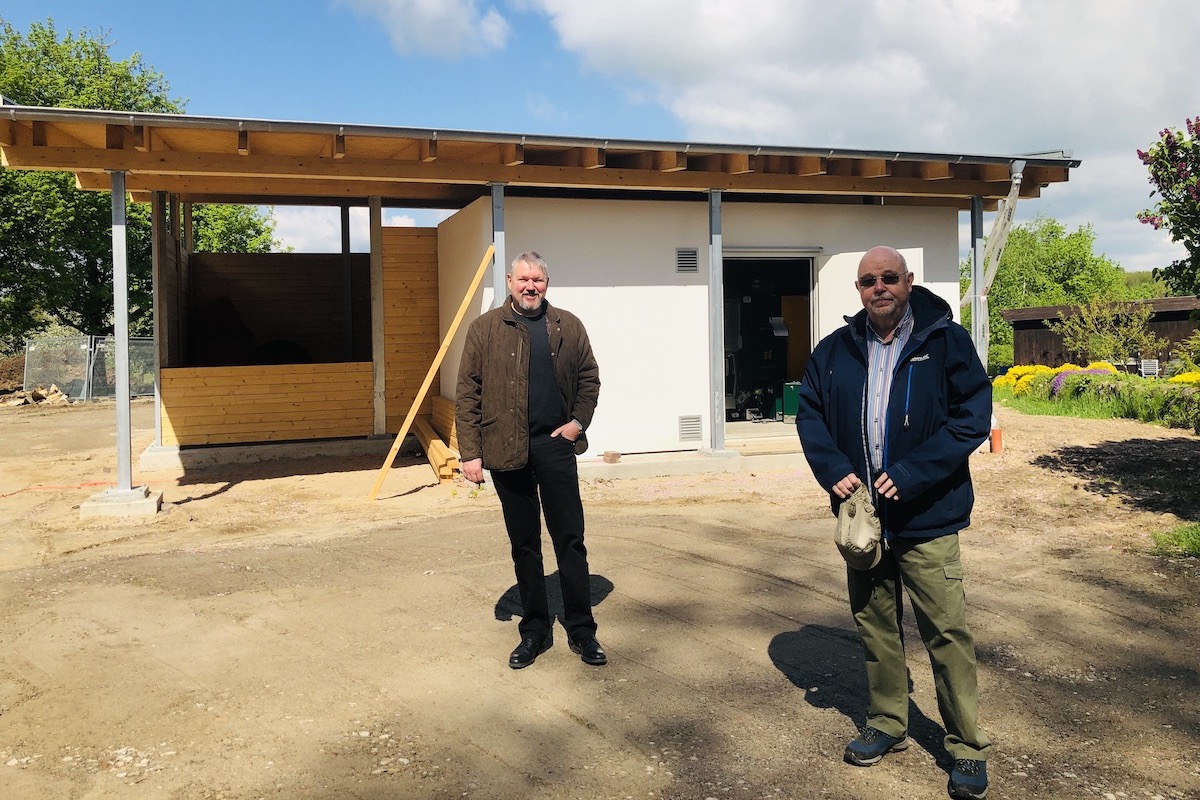 Michael Eggers (li.) und Olaf Dey vor dem Heizhaus. Im Herbst soll es in Betrieb gehen. 