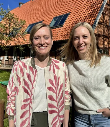 Zwei Frauen schauen in die Kamera.