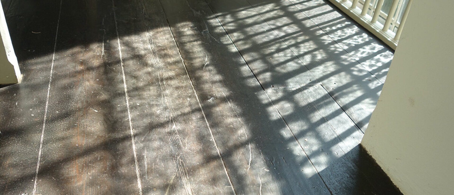 Licht scheint durch ein Fenster, welches vergittert ist, herein