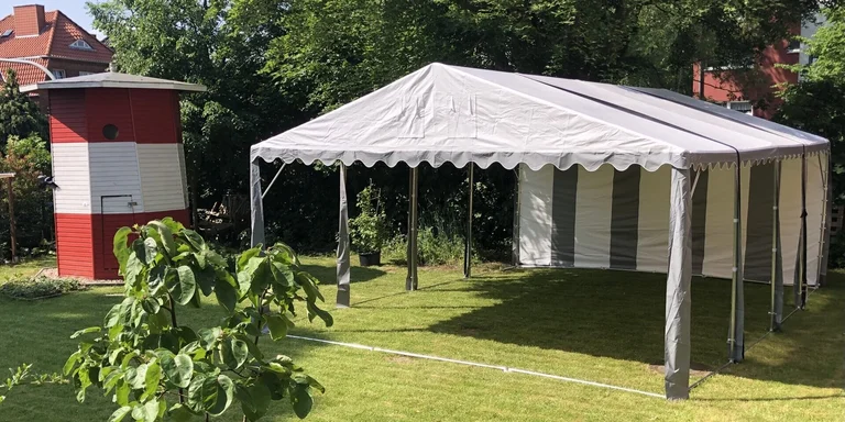 Eine kleine Hütte in der Form eines Leuchtturms steht links neben einem Pavillon