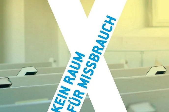 Weißes X auf Kirchenbänken mit blauer Schrift Kein Raum für Missbrauche