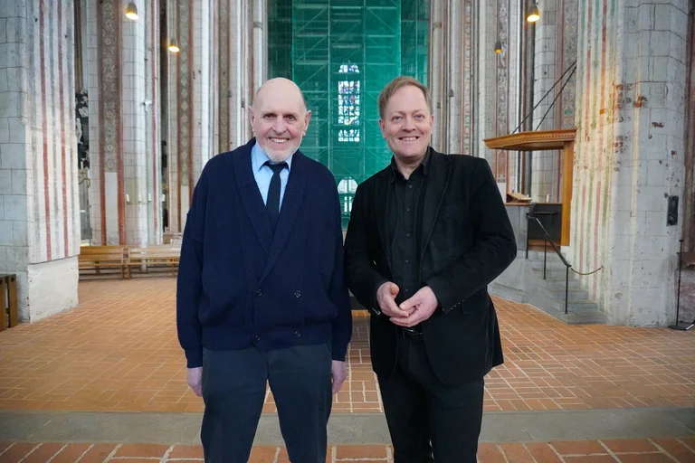 Zwei Männer stehen in der Marienkirche in Lübeck.