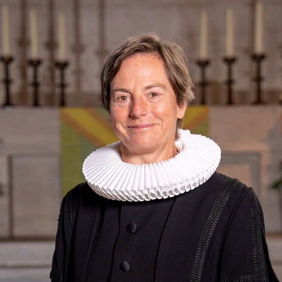 Eine Frau guckt freundlich in die Kamera.