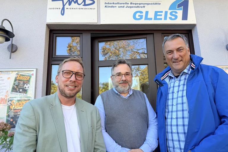 Drei Männer vor einem Gebäude