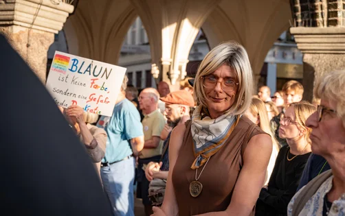 Transfrau Paula Claussen lächelt auf einer Demo in die Kamera.
