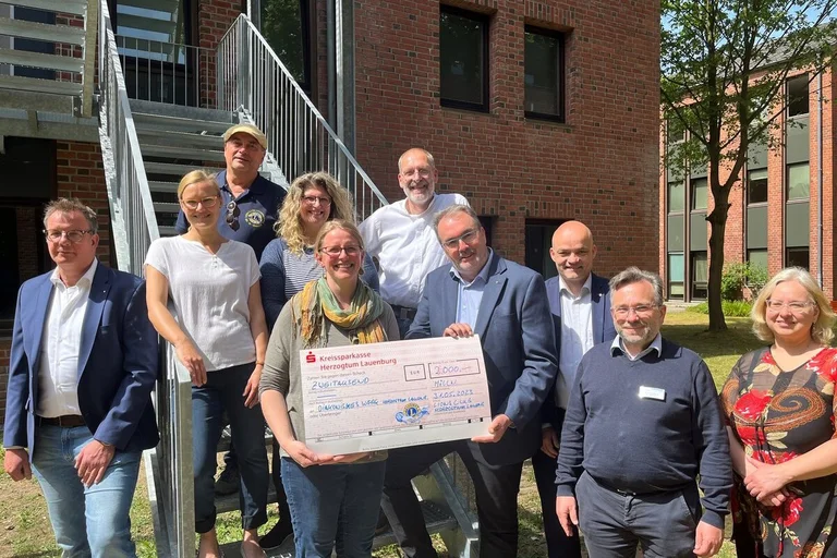 Mehrere Personen stehen an einer Treppe. 