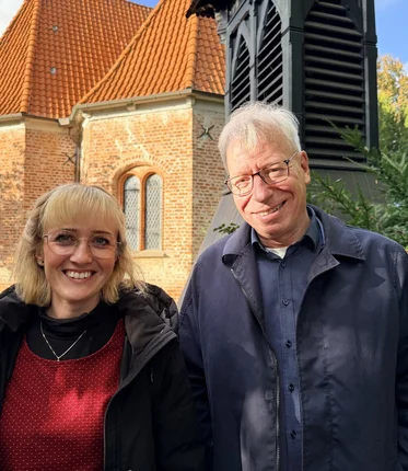 Zwei Menschen stehen vor einer Kirche 