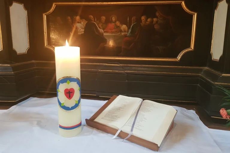 Osterkerze auf dem Altar mit Bibel