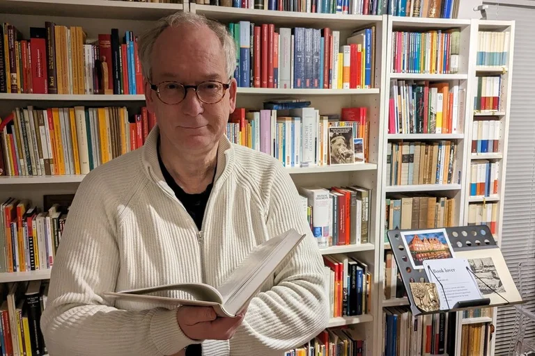 Ein Mann steht vor einem Bücherregal